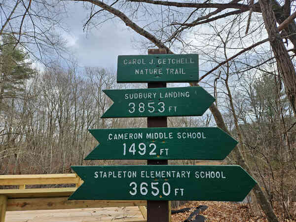 Sign at the Carol Getchell Nature Trail showing distances to various landmarks including Sudbury Landing, Cameron Middle School and Stapleton Elementary School