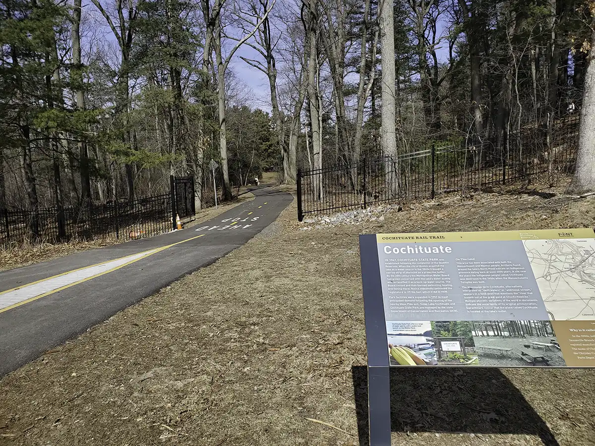 Photo of trail with a sign at the lower right explaining the trail and mentioning the park