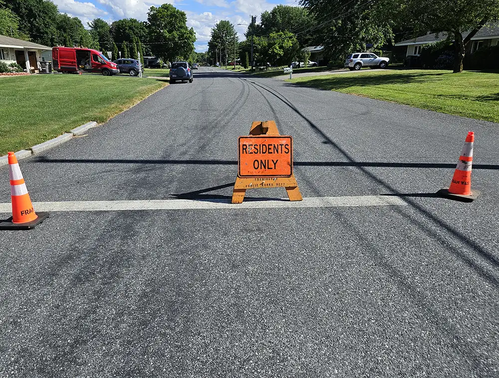 "Residents only" sign and two traffic cones at an intersection